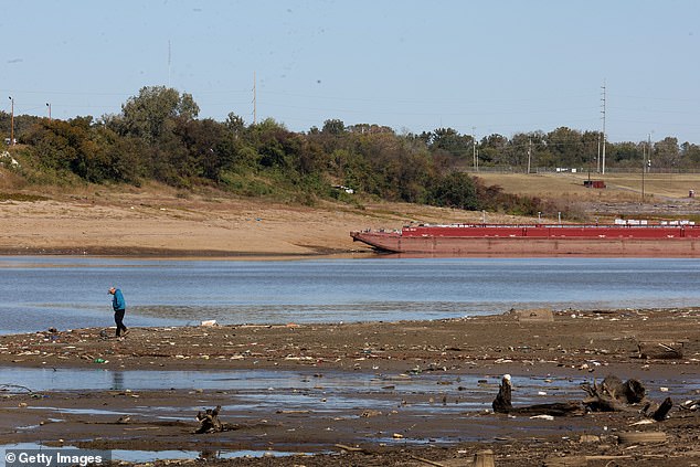 A man walks along the shore of McKellar Lake, a remote corner of the Mississippi River in Memphis, Tennessee, on October 19, 2022