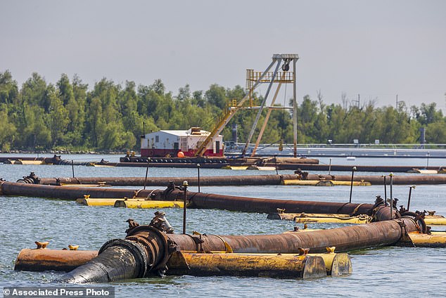 Sediment-carrying pipes cross the Mississippi River, where the U.S. Army Corps of Engineers is building an underwater sill with mud that should slow the flow of saltwater along the Mississippi River south of New Orleans