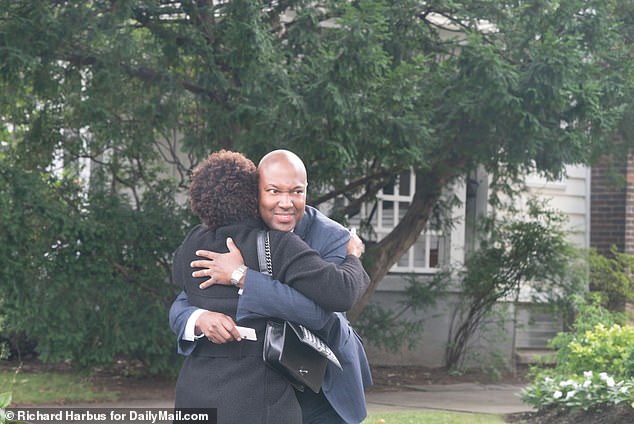 Duroseau hugs a family member after a press conference held outside his home in Forest Hills, Queens, on Thursday