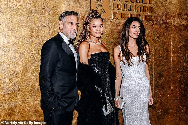 Three's a crowd...Andra posed with George and Amal Clooney as she arrived at the glitzy awards