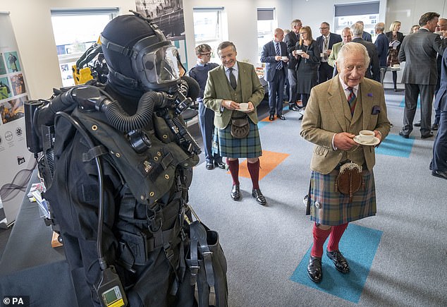 King Charles III (right) looks at diving equipment during his visit to the Global Underwater Hub