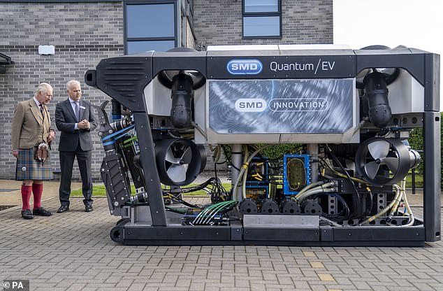 King Charles III looks at an underwater ROV (remote operating vehicle) together with Mike Jones, director of SMD (Soil Machine Dynamics).