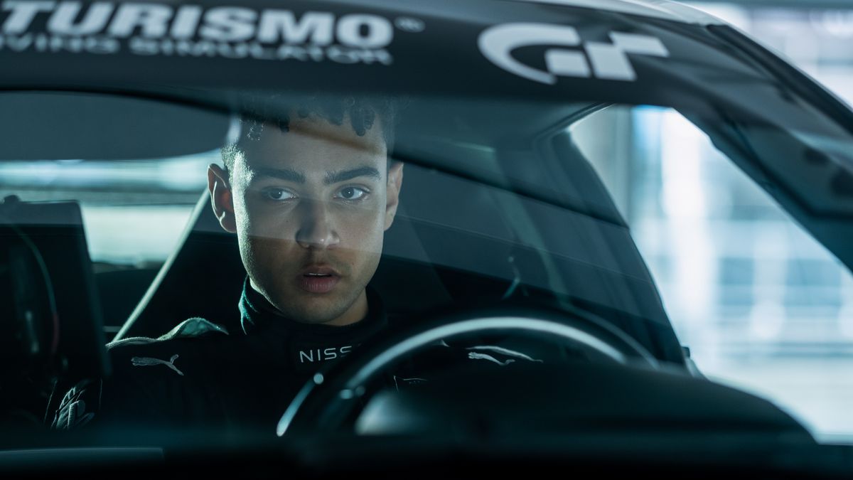 Archie Madekwe as Jann Mardenborough driving a car with a Gran Turismo sticker on the windshield