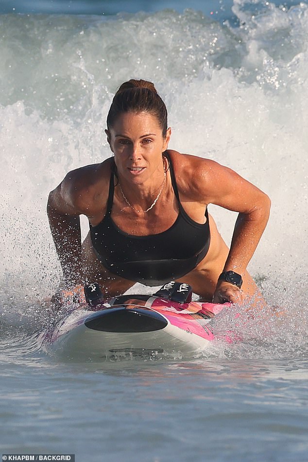 The former Iron Woman showed off her athletic figure in the tight black swimsuit as she was spotted kneeboard surfing some small waves