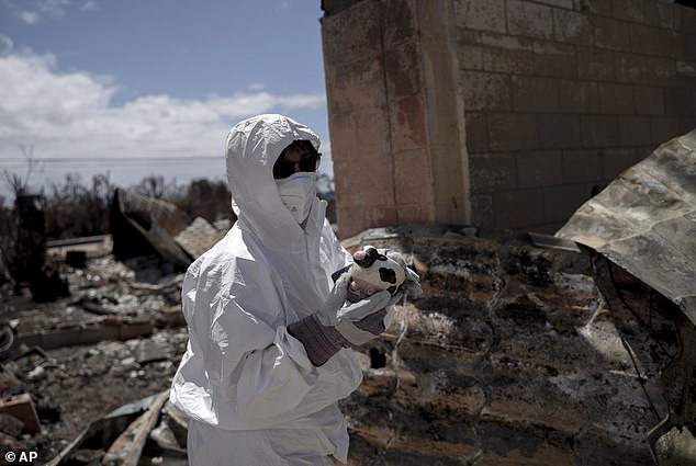 Leola Vierra holds a planter that was part of her cow collection, found in the rubble of her home's porch.  She is one of the residents who can return to their premises in Zone 1-C