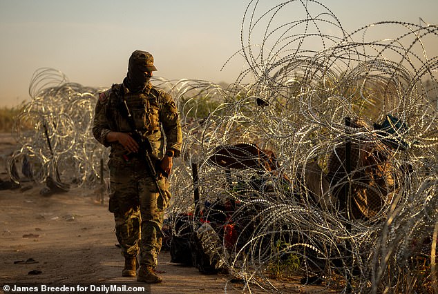 A border agent walked along barbed wire lines near the border in Eagle Pass, Texas