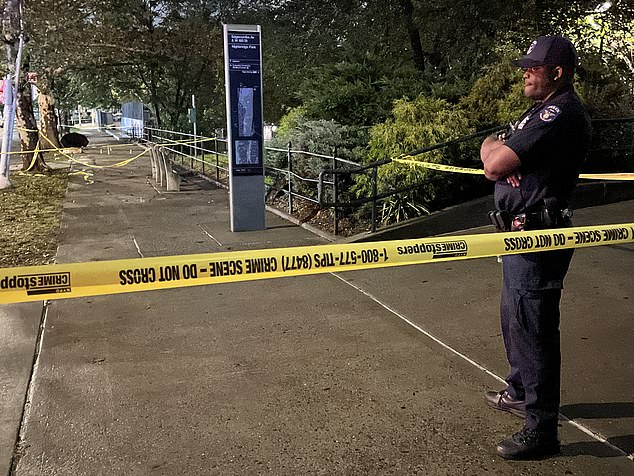 An NYPD officer stands guard after Friday night's murder in Washington Heights