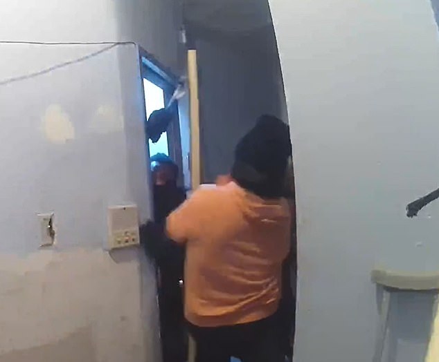 Terrifying footage shows the armed intruder wielding a hammer as he tries to break in