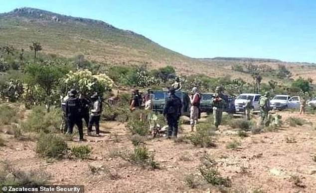 Security forces inspect the farm area where the bodies of six teenagers and a survivor were found on Wednesday