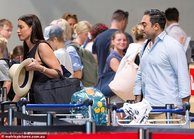 Alex was dressed in a stylish ensemble for the flight, wearing a form-fitting black suit with tight trousers