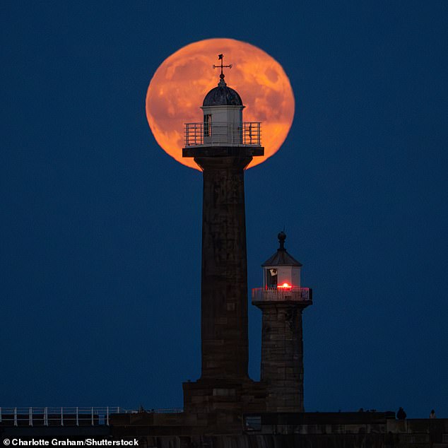 The last supermoon of 2023 rises over Whitby Piers on the North Yorkshire coast