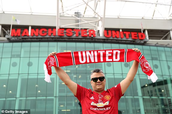 MANCHESTER, ENGLAND - SEPTEMBER 30: A Manchester United fan poses for a photo outside the stadium ahead of the Premier League match between Manchester United and Crystal Palace at Old Trafford on September 30, 2023 in Manchester, England.  (Photo by Charlotte Tattersall/Getty Images)