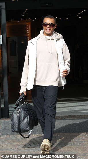 Stylish: Layton Williams looked cheerful as he beamed as he left the hotel in a cream hoody with a white vest jacket