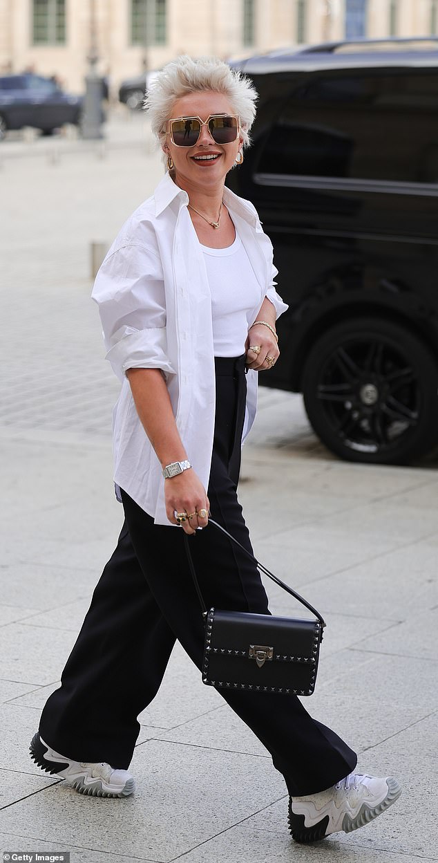 Stylish: Carrying her essentials in a black leather handbag adorned with silver gemstones in rock-chic style, she opted for a pair of chunky white sneakers as her footwear choice