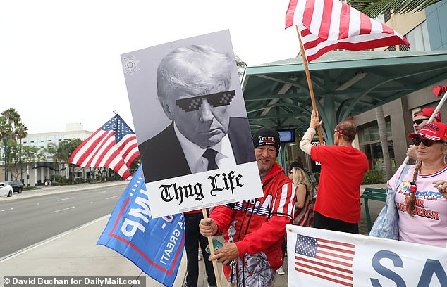 Pro-Trump protesters hold signs as they gather outside the California Republican Party's fall convention in Anaheim during the former president's remarks