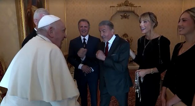 You'll see Stallone raising his fists like a prized warrior for the Pope, wearing his traditional white attire and a skullcap, doing his best impersonation, surrounded by Stallone's family members