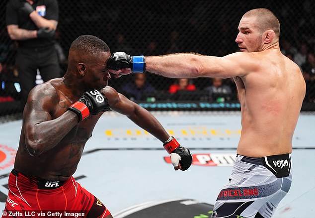 Sean Strickland is pictured landing a punch on Israel Adesanya during his underdog victory that shocked the MMA world