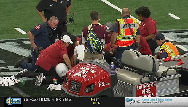 Medics remove John Morgan's helmet as they tend to him in the center of the field