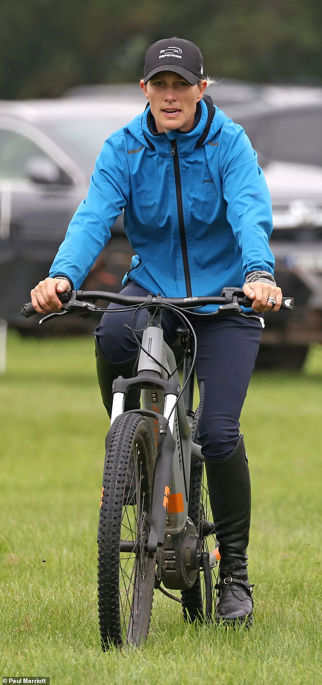 The royal family wore a waterproof blue jacket to protect against the drizzle on Friday, along with a branded black Defender cap and navy blue breeches.