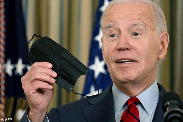 President Joe Biden holds up a face mask during a speech at the White House.  It was not clear if he would mask himself during his meeting with G20 leaders