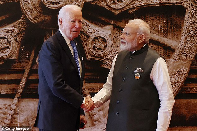 President Joe Biden (left) arrives at the G20 leaders' summit in New Delhi on Saturday, shaking and holding hands with the host, Indian Prime Minister Narendra Modi (right)