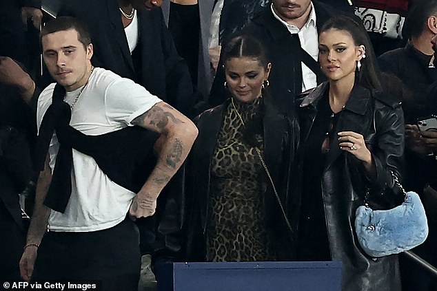 Friends: Brooklyn Beckham seemed in good spirits as he attended the PSG vs Olympique de Marseille football match on Sunday with his wife Nicola Peltz and friend Selena Gomez