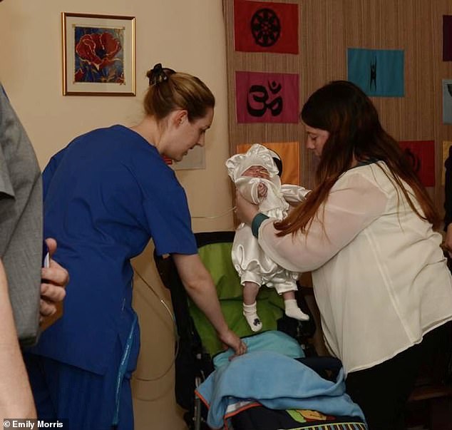 The photo – taken at the Countess of Chester Hospital in 2013 – shows Emily Morris lifting her son Alvin out of a cot as Letby leans in to help