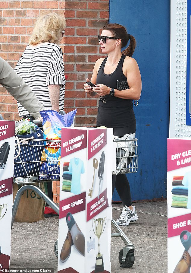 Low key: Wayne Rooney's wife rocked square black shades and kept her chocolate locks in a ponytail