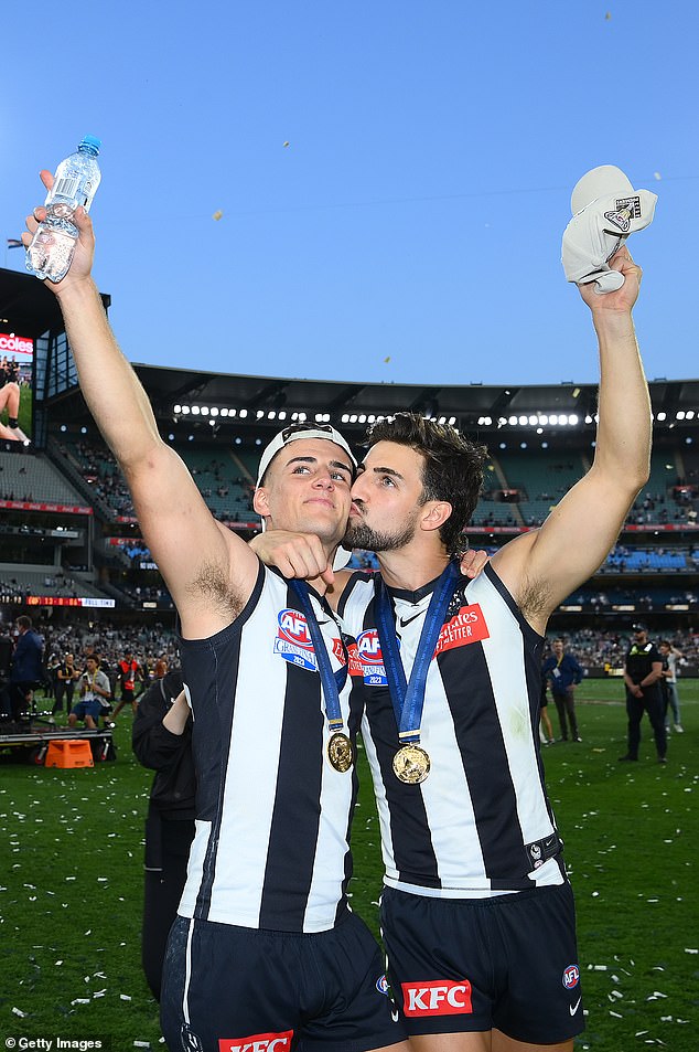 Josh Daicos plants a kiss on his brother Nick Daicos' cheek as they celebrate the Magpies' premiership win over Brisbane