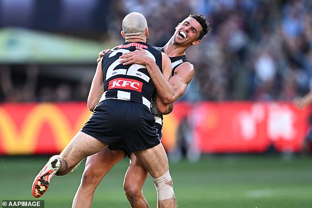 Veterans Steele Sidebottom (front) and Scott Pendlebury (back) celebrate a goal together as they clinched their second AFL premiership