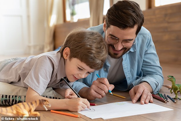 Children do better in primary school if their fathers regularly spend time with them doing interactive activities such as reading, playing, telling stories, drawing and even singing or making music (file photo)