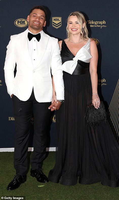 Wests Tigers' Apisai Koroisau and his stunning partner Amy wore matching black and white ensembles, with couples dressing in an emerging 2023 trend. But the flowing pleated skirt and satin bow at the top engulfed her petite figure.