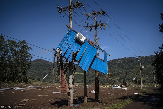 A wall of a house hangs from electricity cables after the passage of an extratropical cyclone in the Muçum, a city in the southernmost Brazilian state of Rio Grande do Sul.  The storm claimed the lives of 41 people, including 15 in Muçum