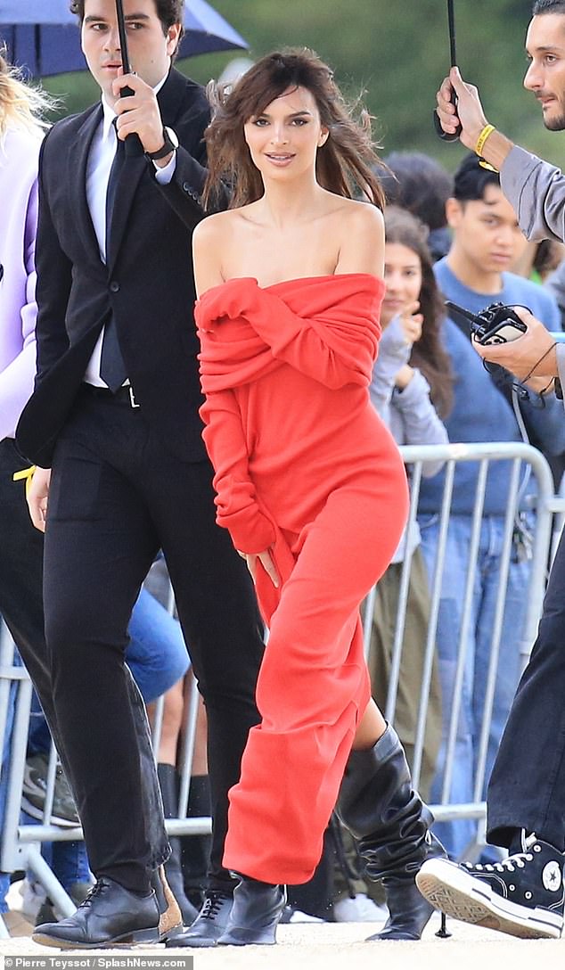 Sexy: Emily Ratajkowski held her red off-the-shoulder dress with thigh slit as it slid down her body as she led the glamor at the Loewe Paris Fashion Week show on Friday