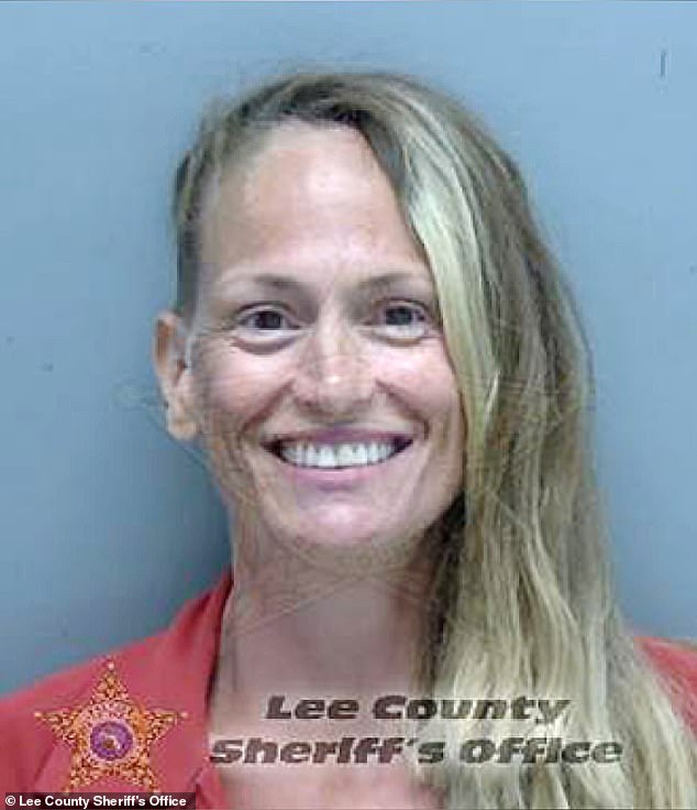 Daugherty, 41, is shown grinning in her mug shot Monday after being charged with child neglect