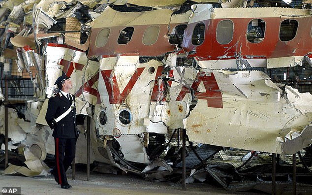 An Italian Carabinieri police officer patrols a hangar in Pratica di Mare, near Rome, Monday, December 15, 2003, the reconstructed wreckage of the Itavia DC-9 passenger plane that crashed on June 27, 1980 near the small Mediterranean island of Ustica.