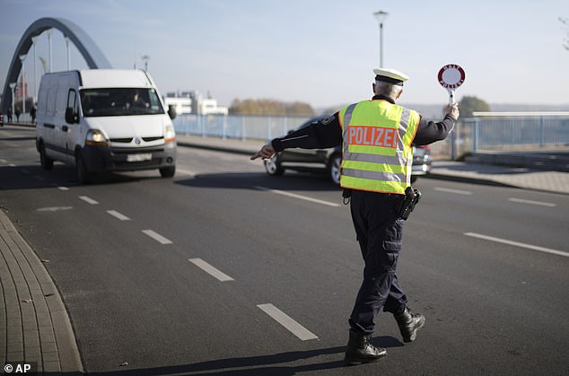 Germany has warned that the Schengen zone will be 'in danger' if the EU cannot protect its external borders, as Berlin imposes new controls on its borders with Poland and the Czech Republic following an influx of migrants.  In the photo: An officer of the German Federal Police stops a van to search for immigrants at the border crossing from Poland to Germany