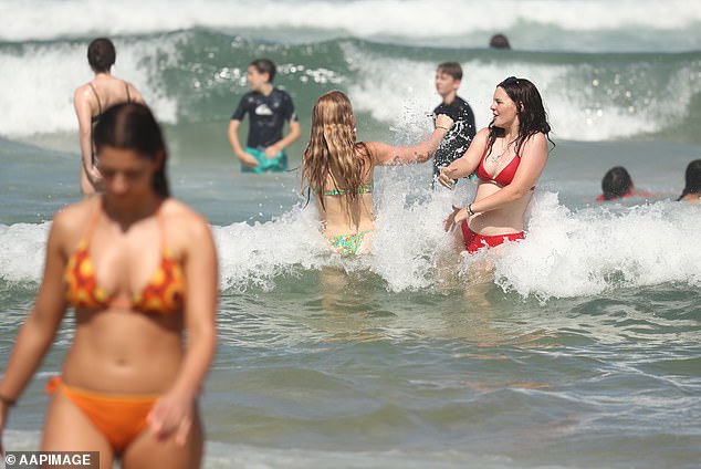 House prices are rising on the Gold Coast, even as property values ​​are falling across much of regional Australia (photo shows swimmers at Surfers Paradise)