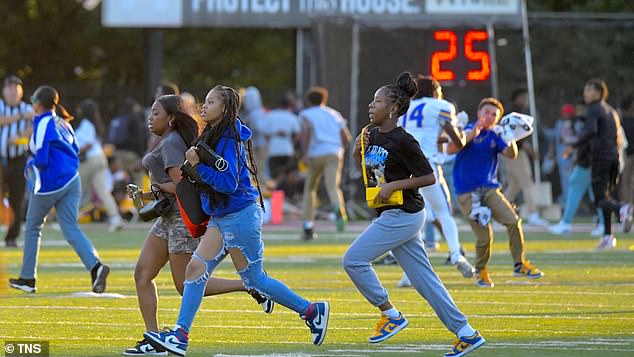 Players and fans take cover as gunfire is heard outside the William F. "Sugar" Cain Dunbar Stadium as Dunbar hosted Loyola Blakefield Friday night at a high school football game in East Baltimore