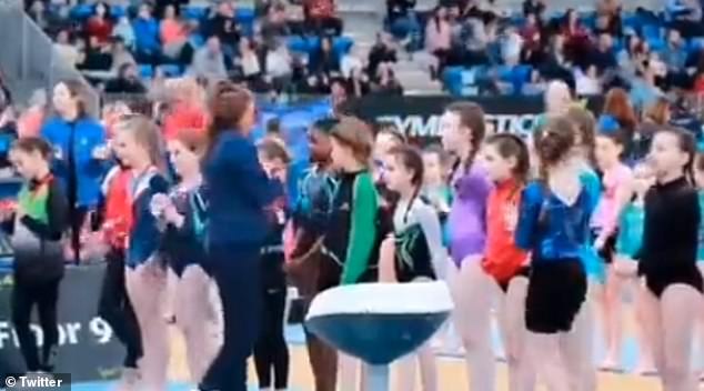 The little girl shuffles forward excitedly, expecting to be presented with the medal, before the referee moves on to the next gymnast in the lineup.