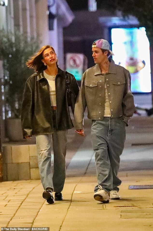 Date night: Meanwhile, Justin looked casual in baggy jeans, a white T-shirt and shielded his shoulders with a gray leather jacket