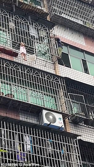 The girl hung helplessly by her neck from the security bars of a fifth-floor window of an apartment building in Chongqing, south-central China.