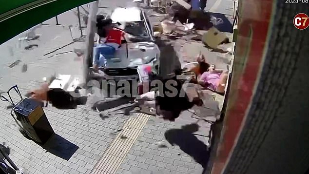 One of the victims was a lady in a pink dress (right) who was slammed feet first into a neighboring building and fell headfirst to the ground