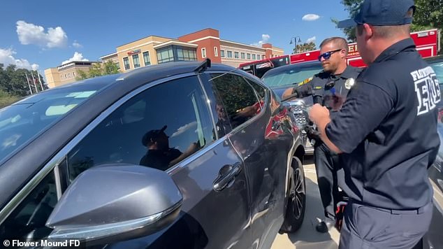 A police officer began poking the driver's side window of the back seat while the firefighter shielded his face in case of debris