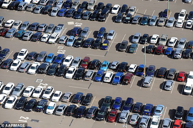 Nearly 100 abandoned vehicles have piled up at Sydney Airport as management tries to get rid of them (photo, aerial view of cars parked at Sydney International Airport)