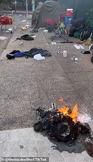 A fire burns on a trash-covered street in Philadelphia's Kensington neighborhood