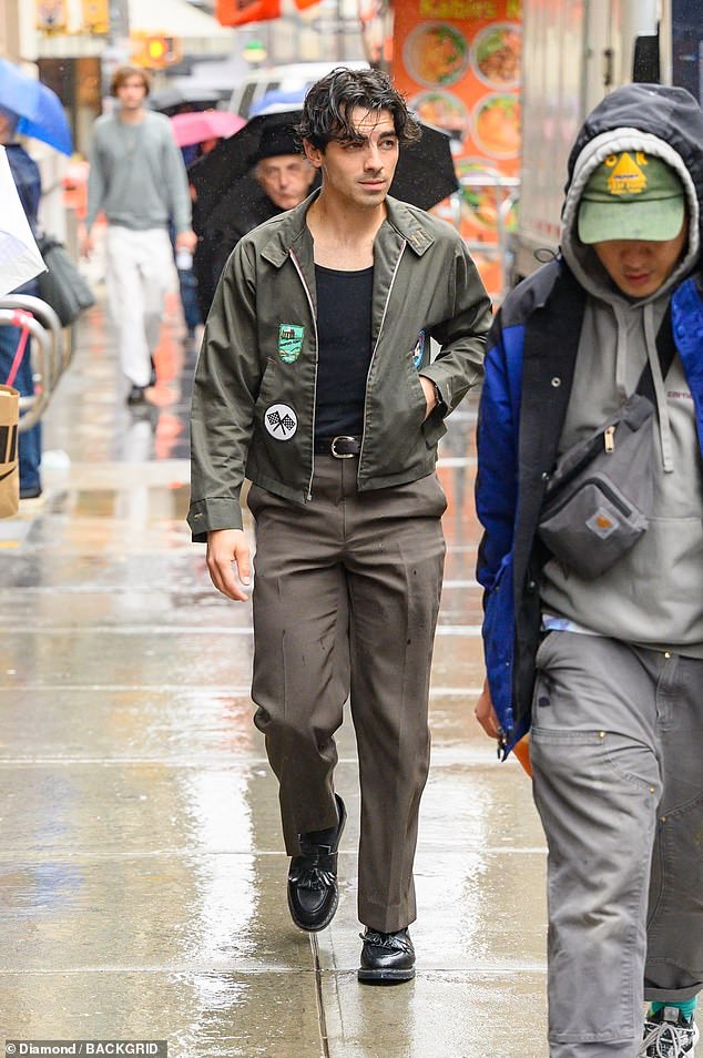 Caught in the rain: Joe rocked black loafers with tassels, and his hair was messy and wet from walking through a light rain shower