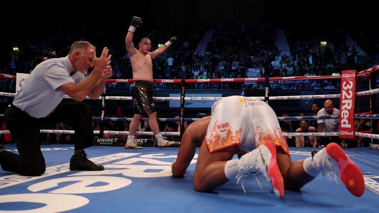 Joe Joyce (right) is knocked down by Zhilei Zhang 