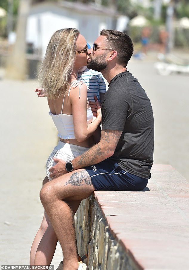 Steamy: Jorgie Porter put on a loving show with her fiancé Oliver Piotrowski on Saturday as they enjoyed a day at the beach in Spain with their son Forest, eight months,