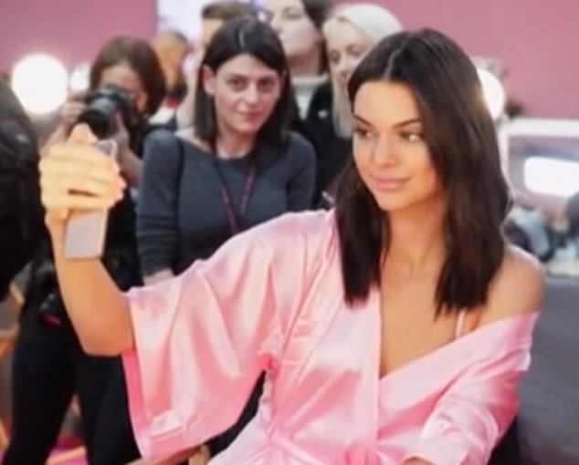 Kendall Jenner took a selfie with the woman behind her, smiling sweetly in her pink Victoria's Secret robe